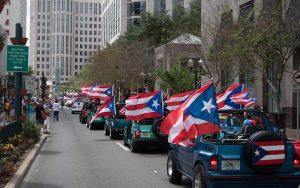 Image of cars with Puerto Rican flags driving down Orange Avenue