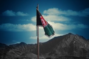 Afghan flag flying over desert hills