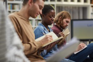 Students sitting in lecture with notebooks